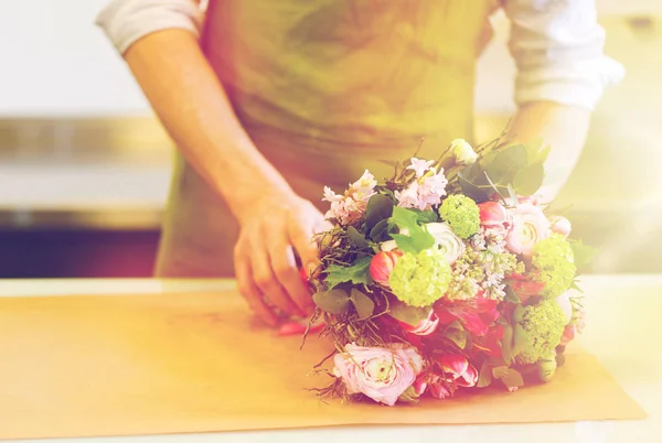 Цветочник заворачивает цветы в бумагу в цветочном магазине — стоковое фото