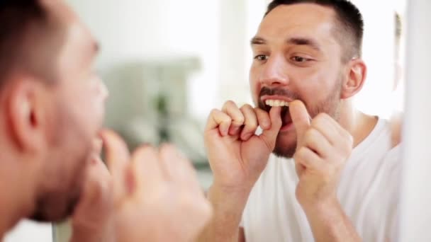 Homem com fio dental, limpeza dos dentes no banheiro — Vídeo de Stock