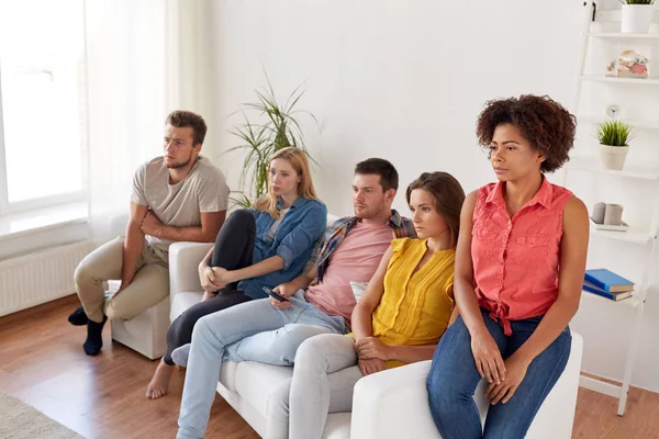 Amigos tristes assistindo tv em casa — Fotografia de Stock