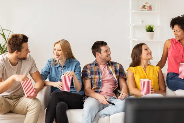 Amis heureux avec popcorn et télécommande TV à la maison — Photo