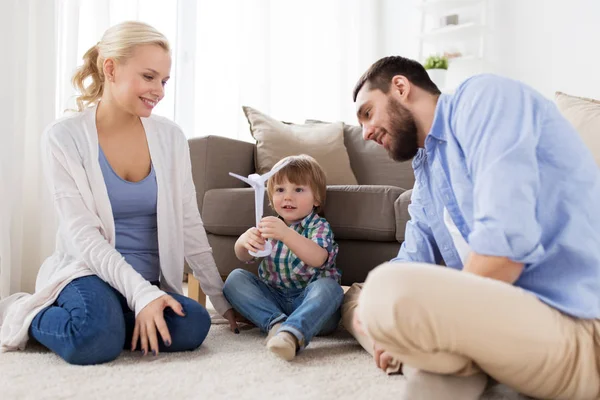 Famiglia felice giocando con turbina eolica giocattolo — Foto Stock