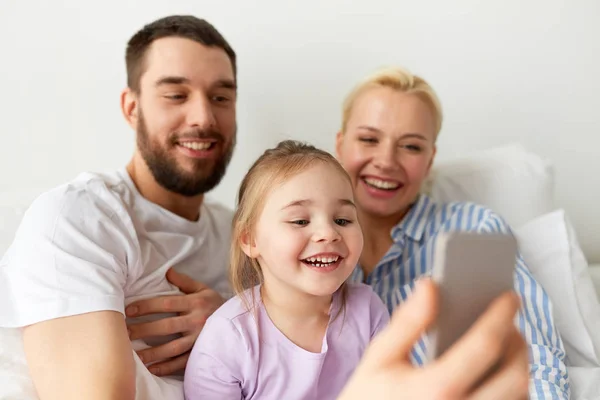 Familia feliz tomando selfie por teléfono inteligente en casa —  Fotos de Stock