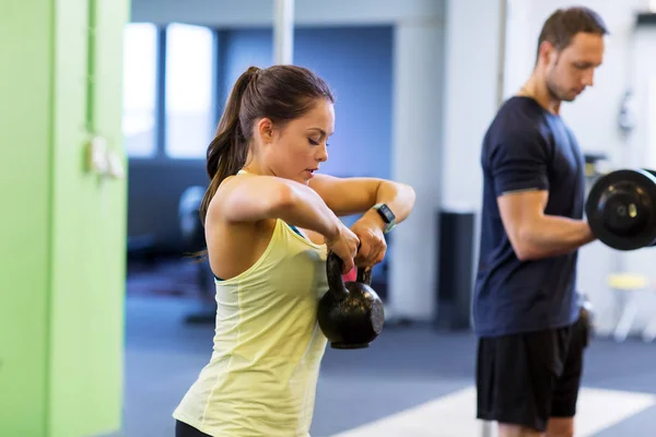 男人和女人与壶在健身房锻炼身体 — 图库照片
