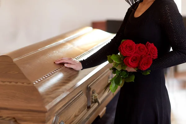 Mujer con rosas rojas y ataúd en el funeral —  Fotos de Stock