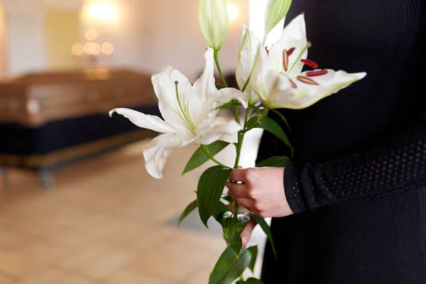 Close up van vrouw met lelie bloemen bij begrafenis — Stockfoto