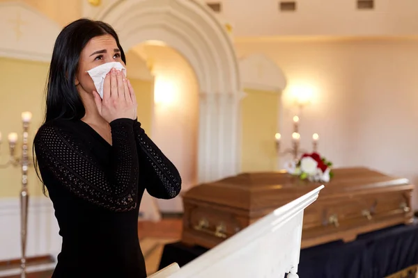 Mulher com caixão chorando no funeral na igreja — Fotografia de Stock