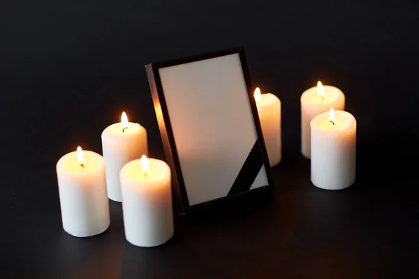 Black ribbon on photo frame and candles at funeral — Stock Photo, Image