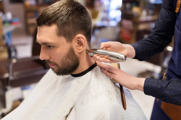 Мужские и парикмахерские руки с триммером стрижка волос — стоковое фото