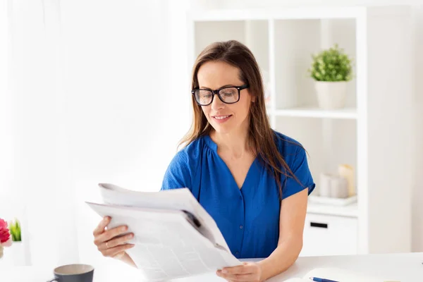 Mujer feliz en gafas leyendo el periódico en la oficina — Foto de Stock