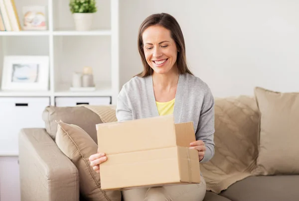 Mujer sonriente abriendo caja de cartón — Foto de Stock