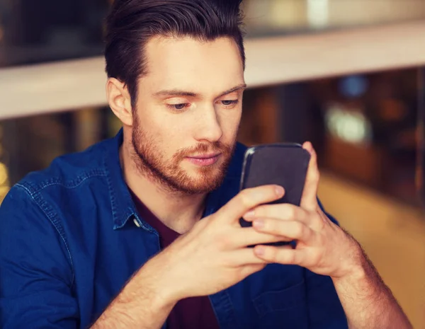 Homem com mensagem de leitura de smartphones no restaurante — Fotografia de Stock