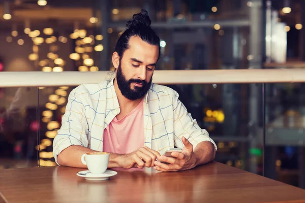 Homme avec smartphone et café au restaurant — Photo