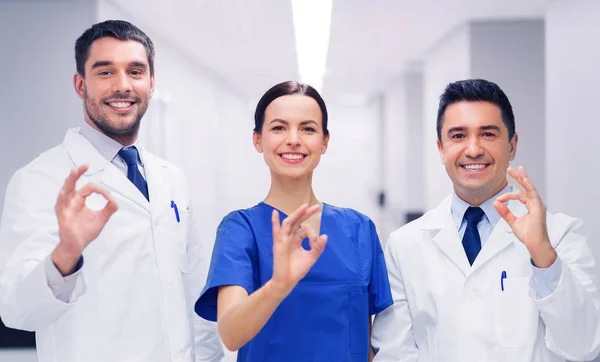 Gruppo di medici in ospedale mostrando segno mano ok — Foto Stock