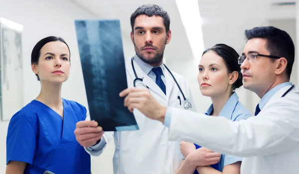 Groep van Medici met het aftasten van de röntgenfoto van de wervelkolom in ziekenhuis — Stockfoto