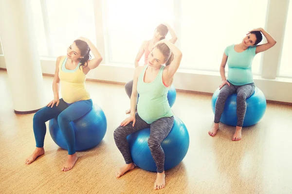 Glada gravida kvinnor utövar på fitball i gym — Stockfoto