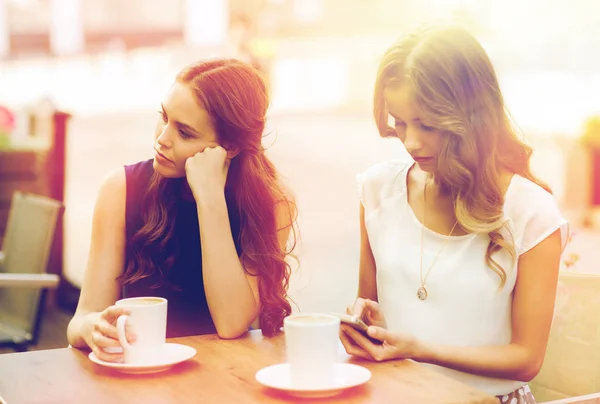 Mujeres con teléfonos inteligentes y café en la cafetería al aire libre — Foto de Stock