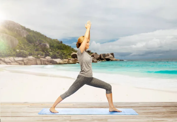 Glückliche Frau macht Yoga-Krieger-Pose am Strand — Stockfoto