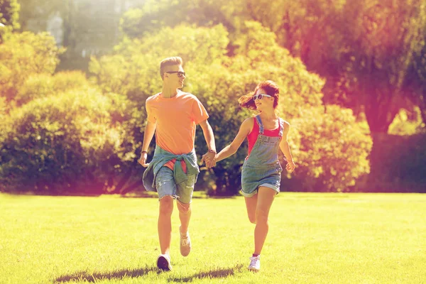 Gelukkige tiener paar draaien op zomer park — Stockfoto