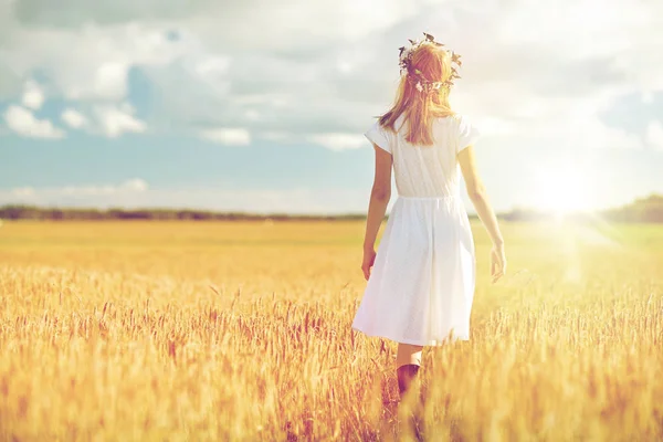 Щаслива молода жінка в квітковому вінку на зерновому полі — стокове фото