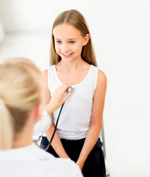 Médico con estetoscopio y niña en el hospital — Foto de Stock