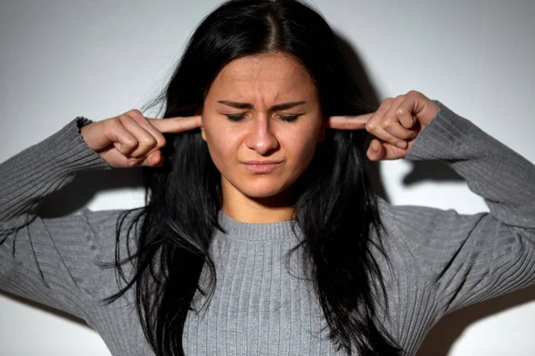 Несчастная женщина закрывает уши пальцами — стоковое фото