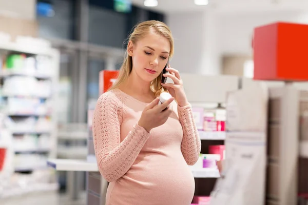 Glückliche Schwangere mit Smartphone in der Apotheke — Stockfoto