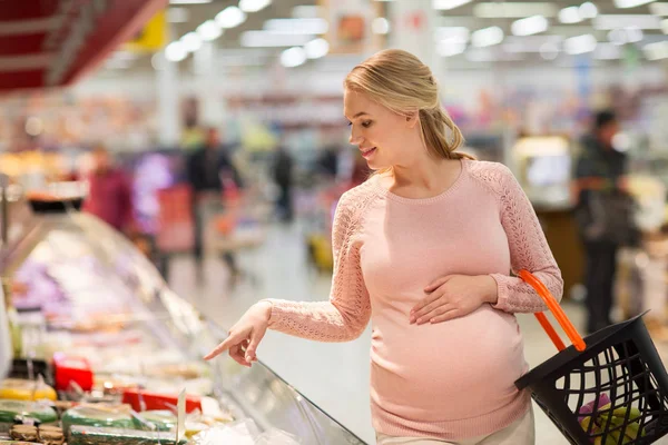 Kobieta w ciąży z koszyk na sklep spożywczy — Zdjęcie stockowe