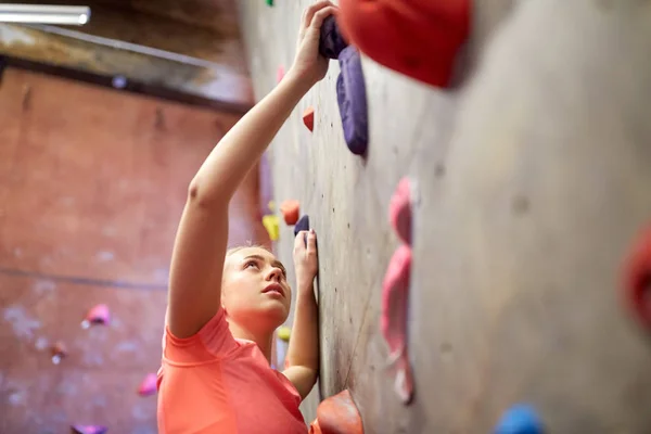 Junge Frau turnt an Kletterwand — Stockfoto