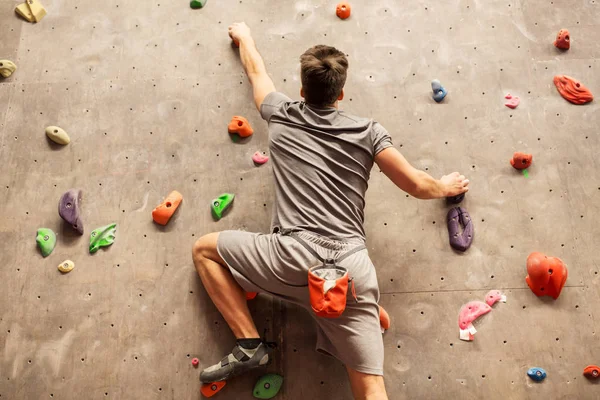 Jovem se exercitando no ginásio de escalada indoor — Fotografia de Stock