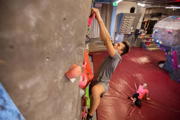 Мужчины и женщины, занимающиеся спортом в помещении для альпинизма — стоковое фото