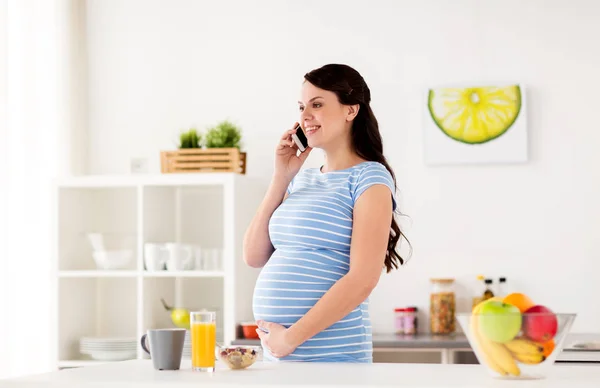 Mujer embarazada feliz llamando en el teléfono inteligente en casa —  Fotos de Stock