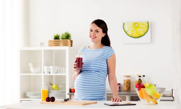 Happy pregnant woman drinking juice at home — Stock Photo, Image