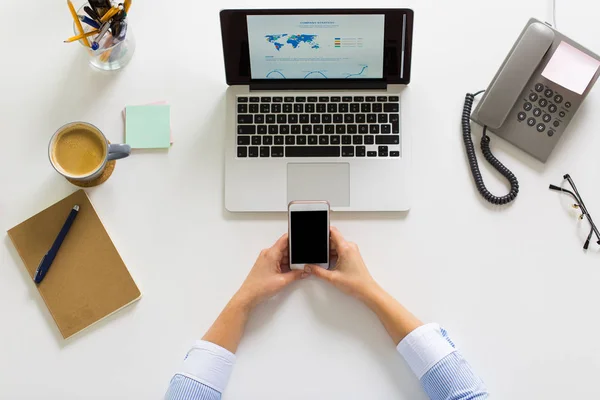 Empresária com laptop e smartphone no escritório — Fotografia de Stock