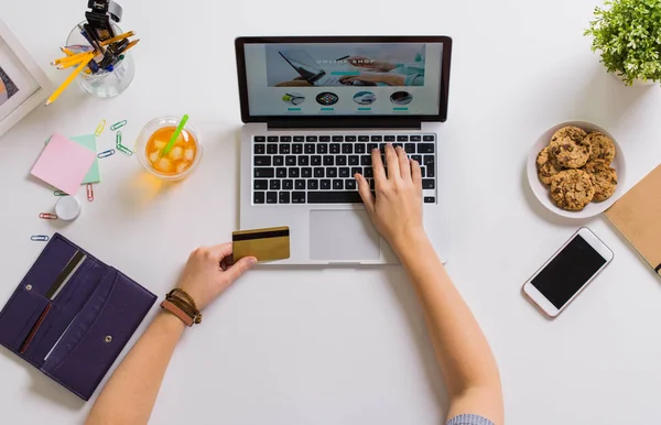 Manos con laptop y tarjeta de crédito en la mesa —  Fotos de Stock