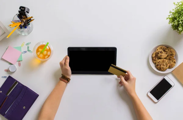 Manos con tableta PC y tarjeta de crédito en la mesa —  Fotos de Stock