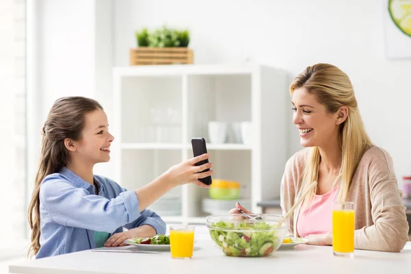 집에서 저녁을 먹고 있는 스마트폰을 가진 행복 한 가족 — 스톡 사진