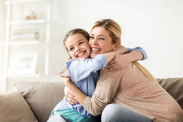 Feliz familia sonriente abrazándose en el sofá en casa —  Fotos de Stock