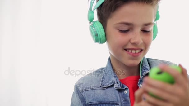 Happy boy met smartphone en hoofdtelefoon thuis — Stockvideo