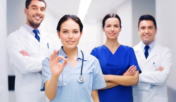 Grupo de médicos no hospital mostrando sinal de mão ok — Fotografia de Stock
