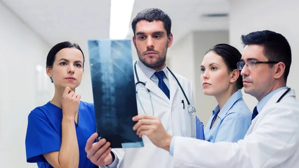 Grupo de médicos con radiografía de columna vertebral en el hospital — Foto de Stock