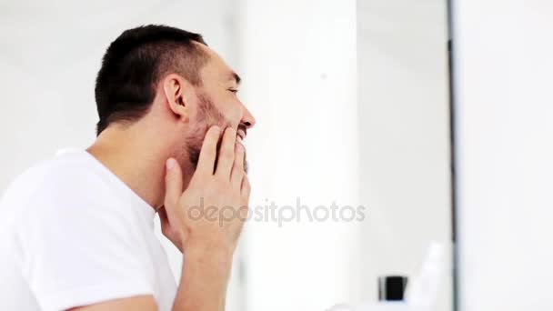 Счастливый молодой человек ищет зеркало в домашней ванной комнате — стоковое видео