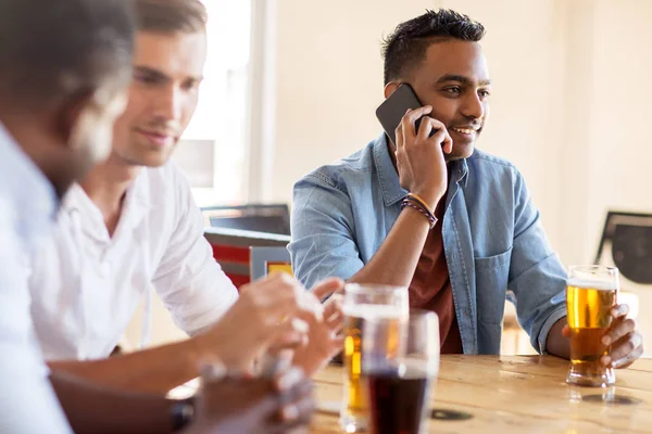 Man calling on smartphone and drinking beer at bar — Stock Photo, Image