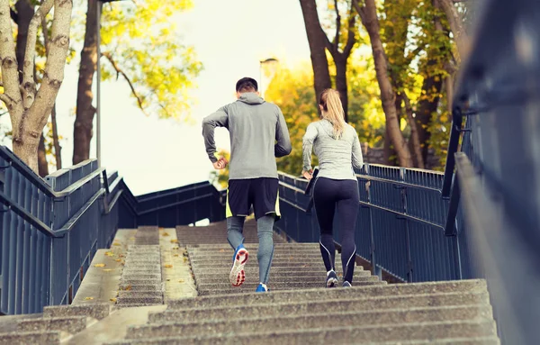 Couple running upstairs in city park — Stock Photo, Image