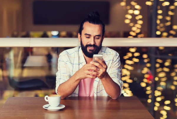 Glücklicher Mann mit Smartphone und Kaffee im Restaurant — Stockfoto