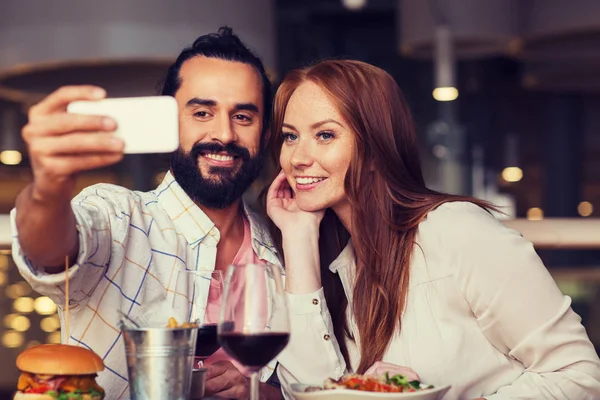 Couple taking selfie by smartphone at restaurant — Stock Photo, Image