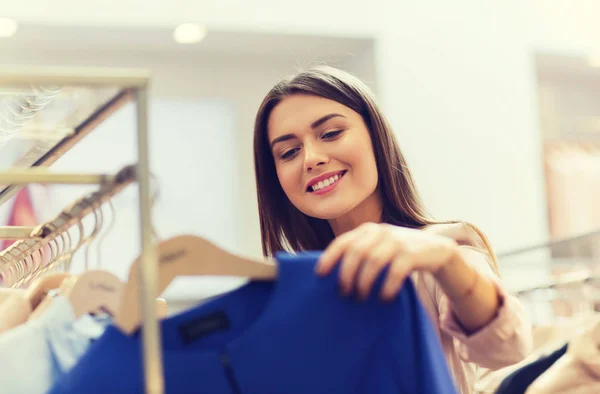 Ευτυχισμένη κοπέλα επιλέγουν ρούχα σε εμπορικό κέντρο — Φωτογραφία Αρχείου