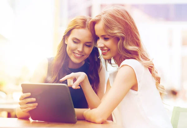 Mujeres jóvenes felices con la PC tableta en la cafetería al aire libre —  Fotos de Stock