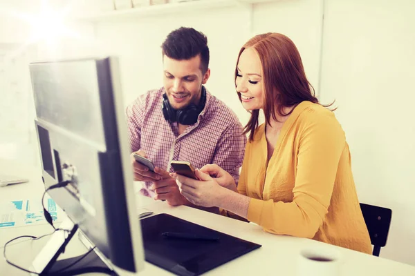 Équipe créative heureuse avec smartphones au bureau — Photo