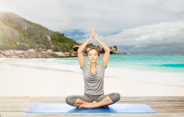 Vrouw mediteren in yoga lotus pose op strand — Stockfoto