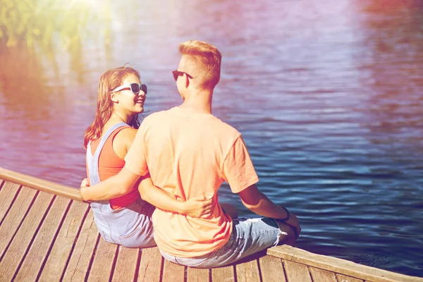 Šťastný dospívající pár objímání na řece kotviště — Stock fotografie